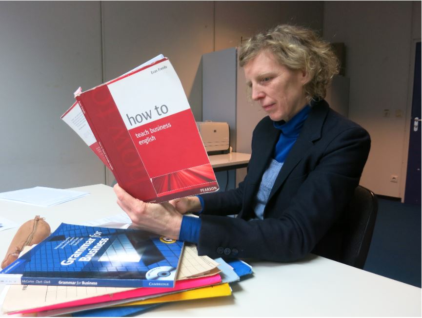 Woman sitting at a table reading a book