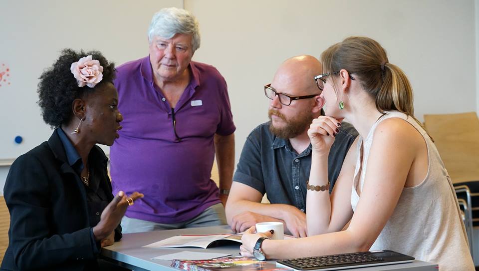 Group of four teachers discussing around a table.