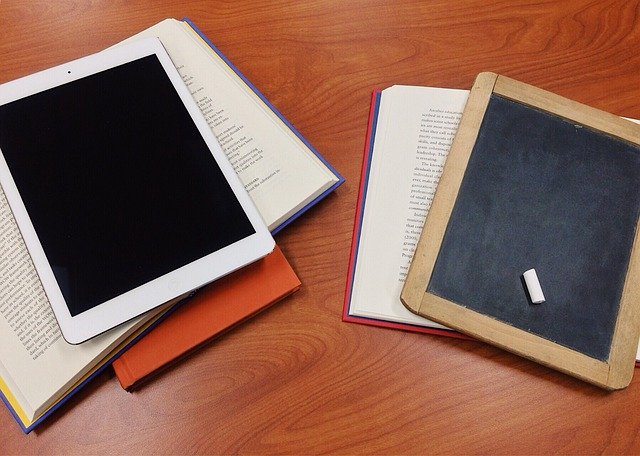 Books, a chalkboard and a tablet on a table